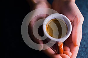 The girl is holding a cup of American coffee.