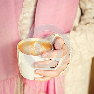 Girl holding a cup of coffee or hot chocolate or chai tea latte.