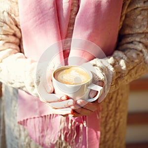 Girl holding a cup of coffee or hot chocolate or chai tea latte.