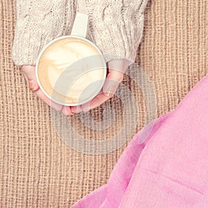 Girl holding cup of coffee with latte art. Leasure time concept.