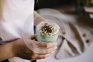 Girl is holding cup of green mint coffee with cream and decoration. Milk shake, cocktail, frappuccino. Unicorn coffee, unicorn foo