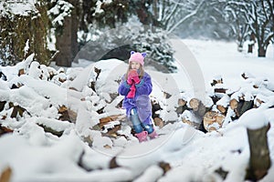 girl holding cup of hot drink and sitting on grass. female hands holding hot chocolate with marshmallow in a red mug.