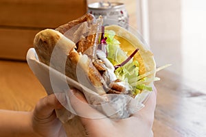 Girl holding a delicious doner in her hands / Girl eating a doner