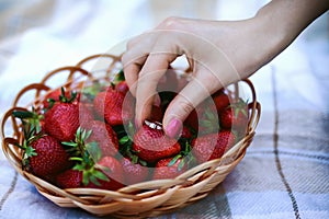 Girl holding an engagement ring near a strawberry