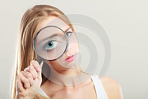 Girl holding on eye magnifying glass loupe