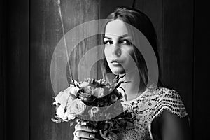 Girl holding flowers in hands, young beautiful bride in white dress holding wedding bouquet, bouquet of bride from rose cream