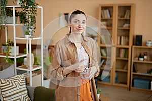 Girl Holding Glass Watering Can And Smiling at Camera at Home