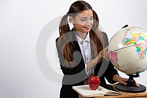 Girl holding globe, looks at it near book, apple. White background with space