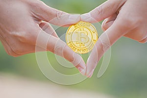 Girl holding a golden bitcoin in her hand, Crypto currency concept.