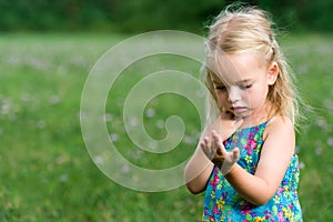 Girl holding grasshopper, curiosity and education concept