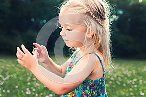 Girl holding grasshopper, curiosity and education concept