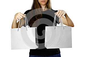 Girl holding a gray paper gift bag. Close up. Isolated background