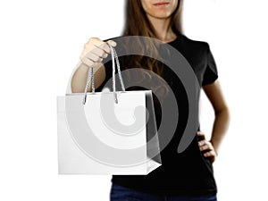 Girl holding a gray paper gift bag. Close up. Isolated background