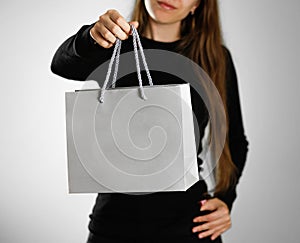 Girl holding a grey gift bag. Close up. background