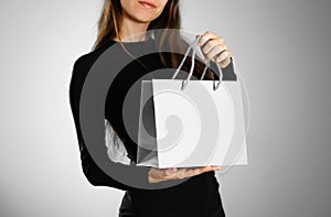 Girl holding a grey gift bag. Close up. Isolated background