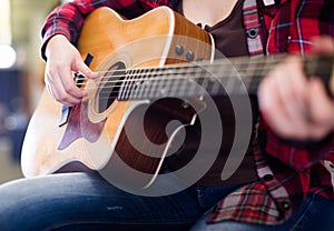 Girl holding guitar. Focus on strings of guitar