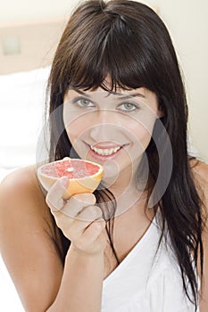 Girl holding of half grapefruit