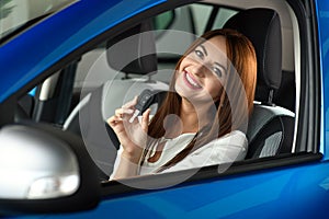 Girl holding in hands keys from new car