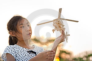 Girl holding helicopter wooden plane toy