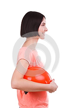 The girl is holding a helmet in her hand. Side view on white isolated background