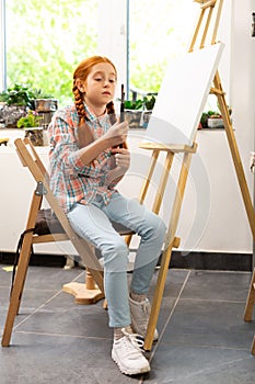 Girl holding her painting brushes before painting in art school