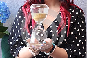 the girl is holding an hourglass.