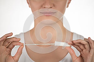 A girl is holding a hygienic tampon and smiling on a white background