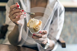 Girl holding ice cream, hands holding ice cream, eating ice cream.