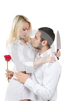 Girl holding knife traitor. man with rose in his