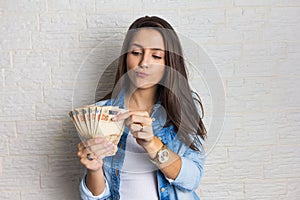 Girl holding a large amount of cash, a lot of money from Brazil. Business, income, loan, pay, buy, wealth