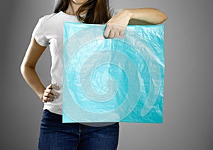Girl holding a light blue plastic bag. Close up. Isolated background