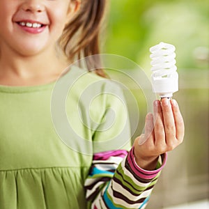 Girl holding light bulb