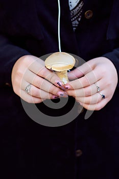 The girl is holding a little mushroom. Dark background