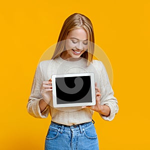 Girl holding and looking at digital tablet with blank screen