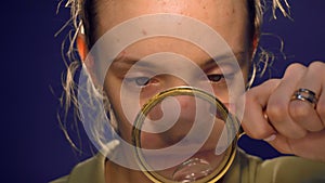 Girl holding a magnifying glass and look through it