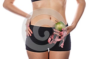 Girl holding measuring tape and green apple.