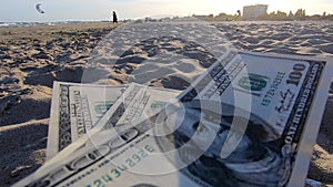 Girl holding money bill of 300 dollars on background of sandy beach