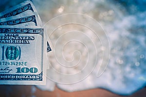 Girl holding money bill of 300 dollars on background of sea ocean