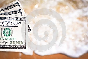 Girl holding money bill of 300 dollars on background of sea ocean