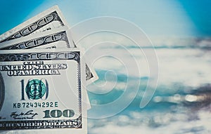 Girl holding money bill of 300 dollars on background of sea ocean