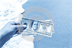 Girl holding a money bill of 300 dollars on background of sea waves