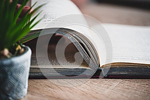 girl holding a old book, wooden table