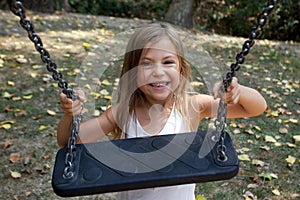 Girl holding onto swing photo