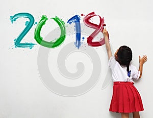 Girl holding a paint brush painting happy new year 2018