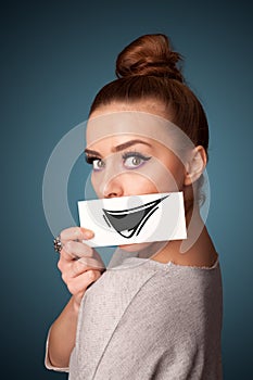 girl holding paper with funny smiley drawing on gradient background