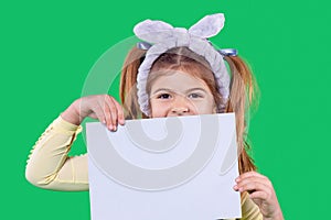 The girl is holding the paper in her hands closing the mouth and on her head is a violet bandage, ears.