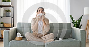 Girl is holding paper tissue and blowing nose