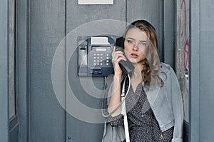 Girl holding a payphone handset in her hand