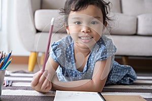 The girl holding a pencil and smiling, aisan girl are drawing and happily at home photo