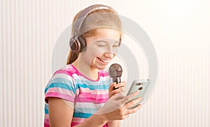 Girl holding phone in one hand and microphone in another